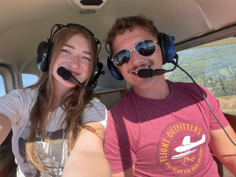 Noah Wince and a passenger smiling in the cockpit during a flight